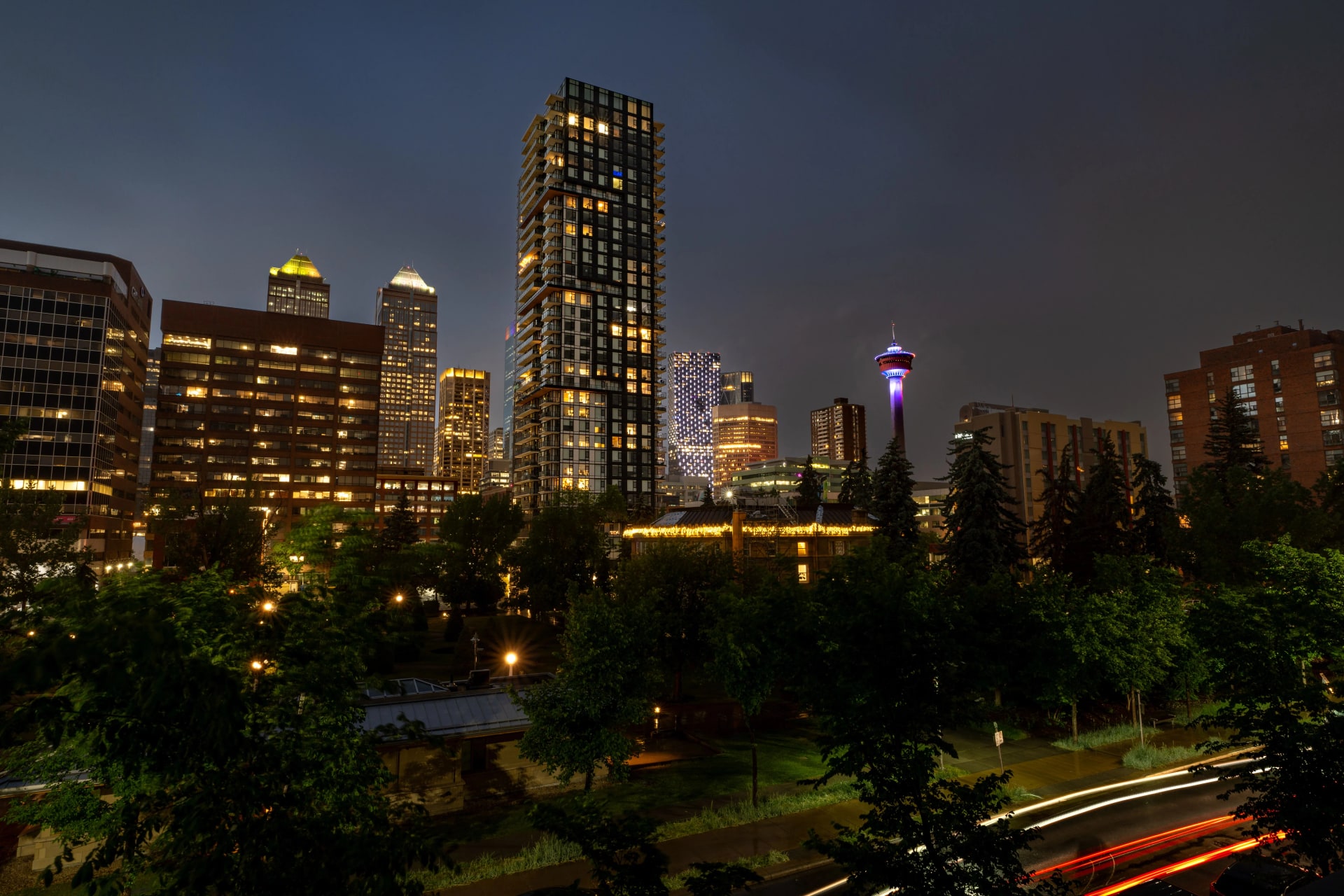 Calgary at night: the downtown skyline lit up above the trees.